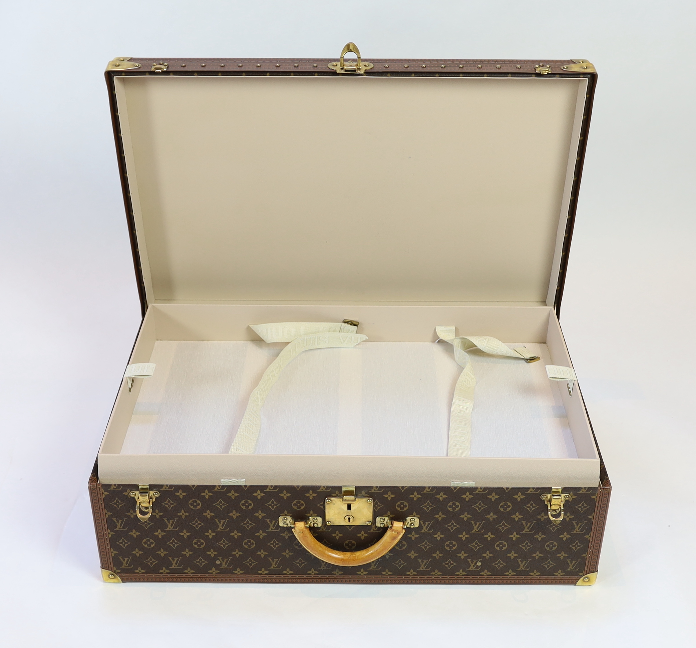A Louis Vuitton monogrammed canvas and tan leather suitcase, 81cm wide, 26cm deep, 52cm high